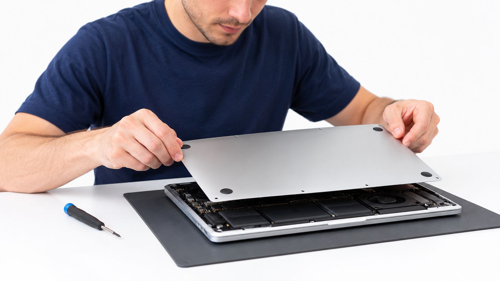 How to Sell My Mac: A Practical UK Guide 2 A technician performing repairs on an open MacBook laptop computer placed on a desk workspace.